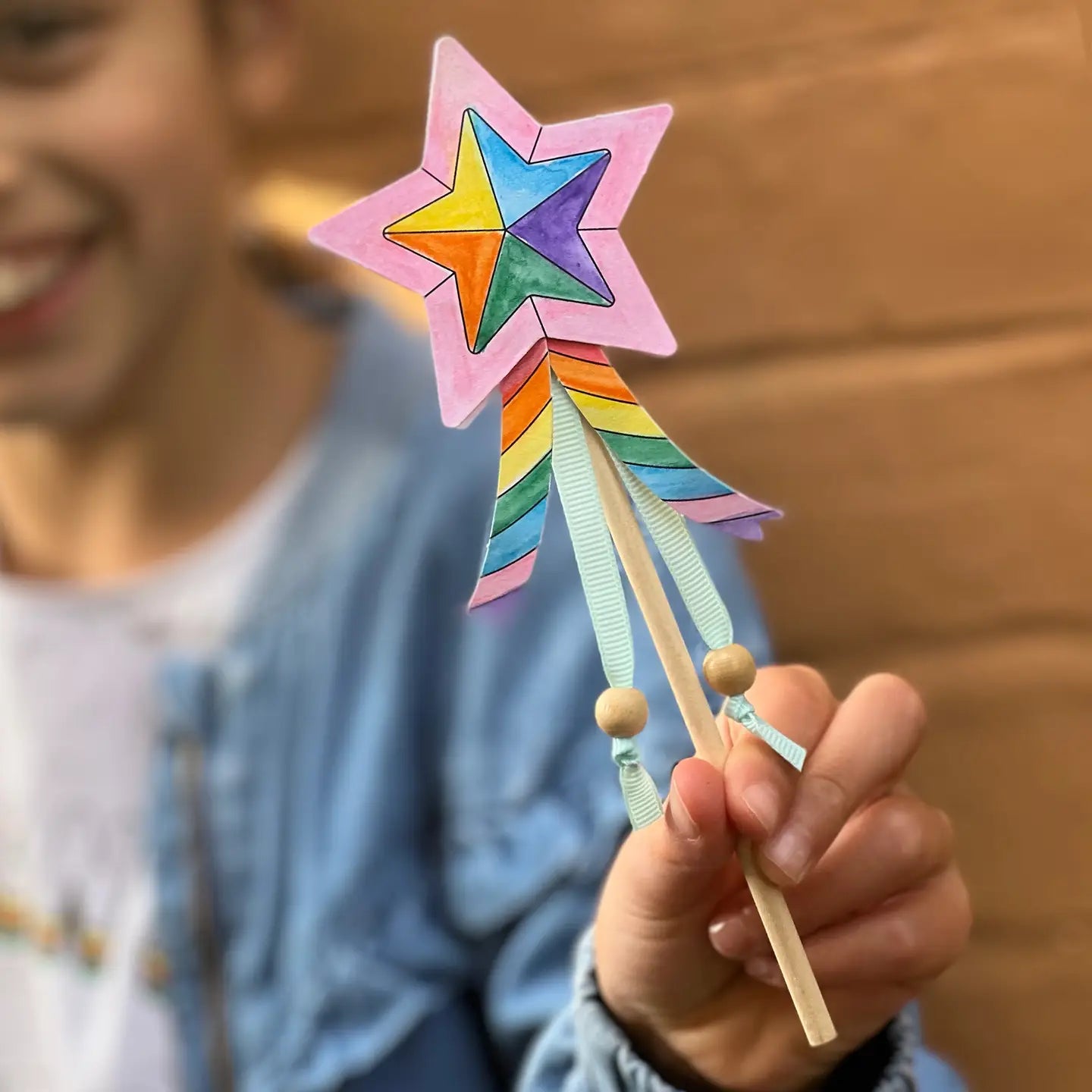 Colorful star-shaped wand held by a person with a blurred background