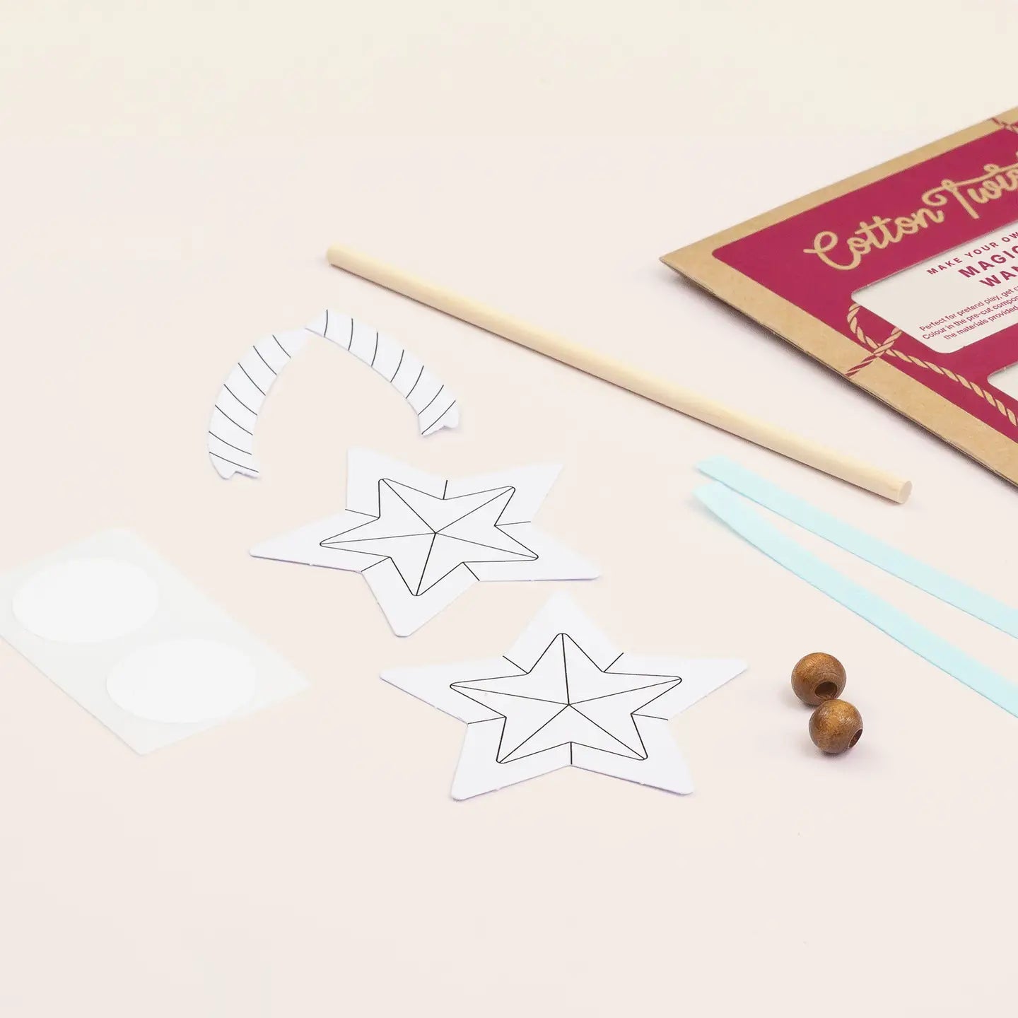 Star-shaped templates and wooden sticks on a light surface with a box labeled 'Cotton Twine' in the background.