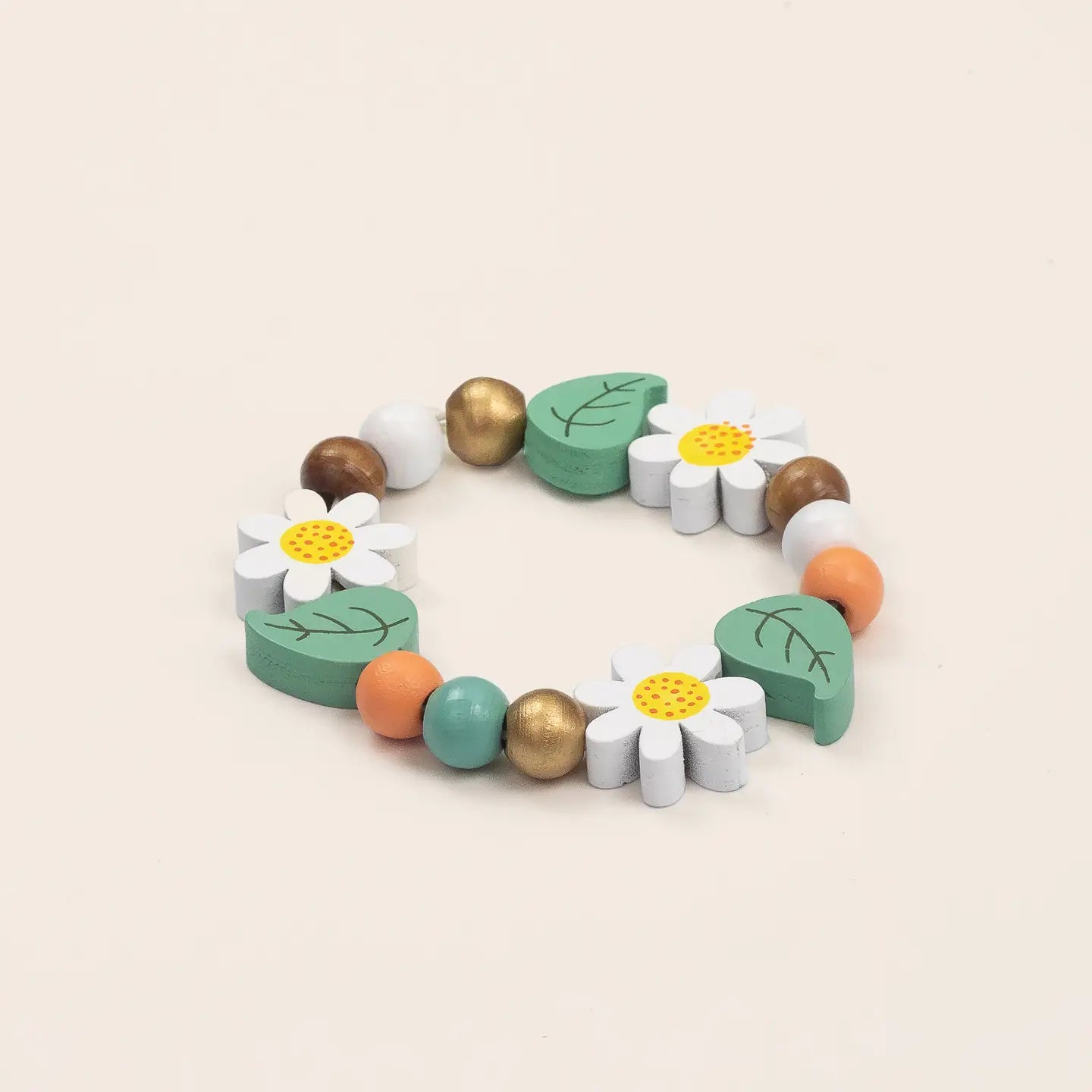 Colorful wooden bracelet with flowers and leaves on a beige background